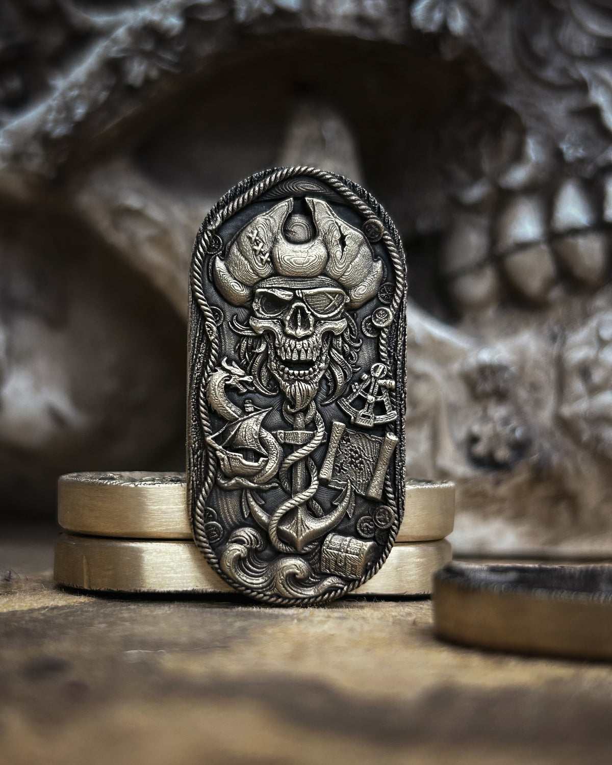 Front view of the pirate skull fidget pill with an eye patch, tricorn hat, ship, treasure map and rope-wrapped anchor.