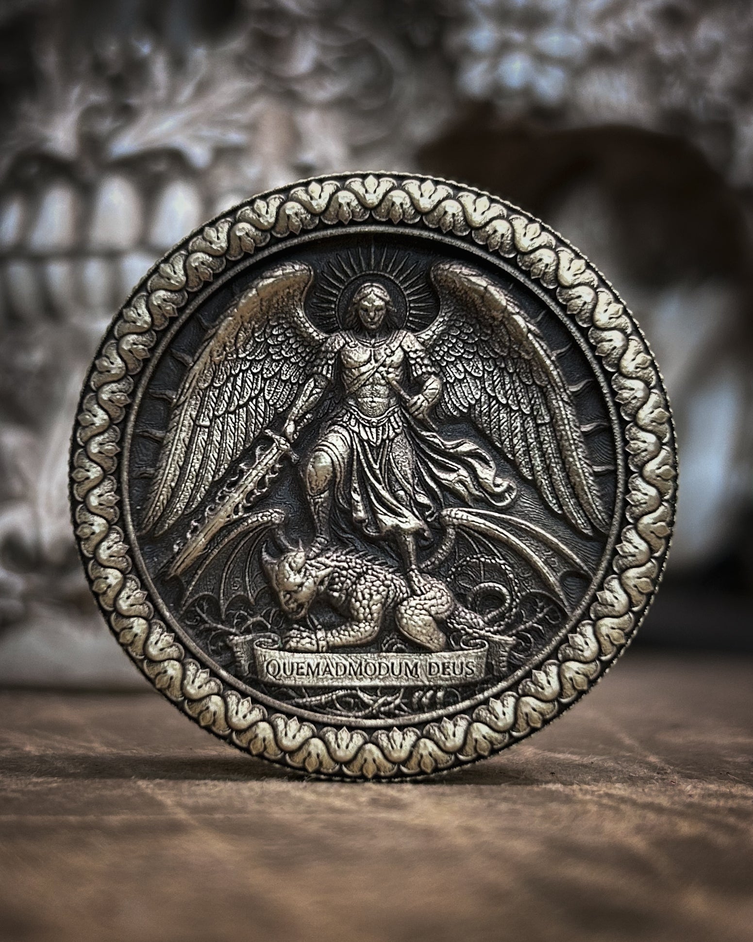 Decorative coin with angelic design on a wooden surface