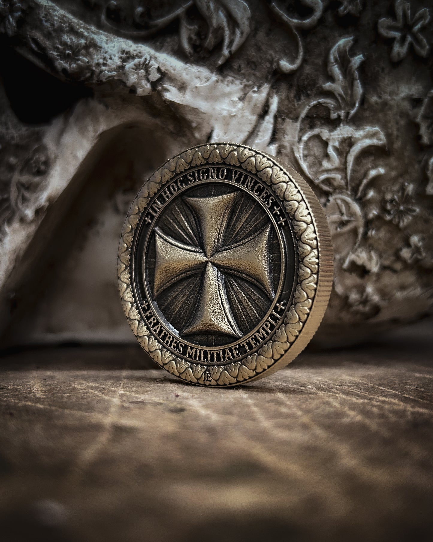 Bronze coin with intricate design on a textured surface