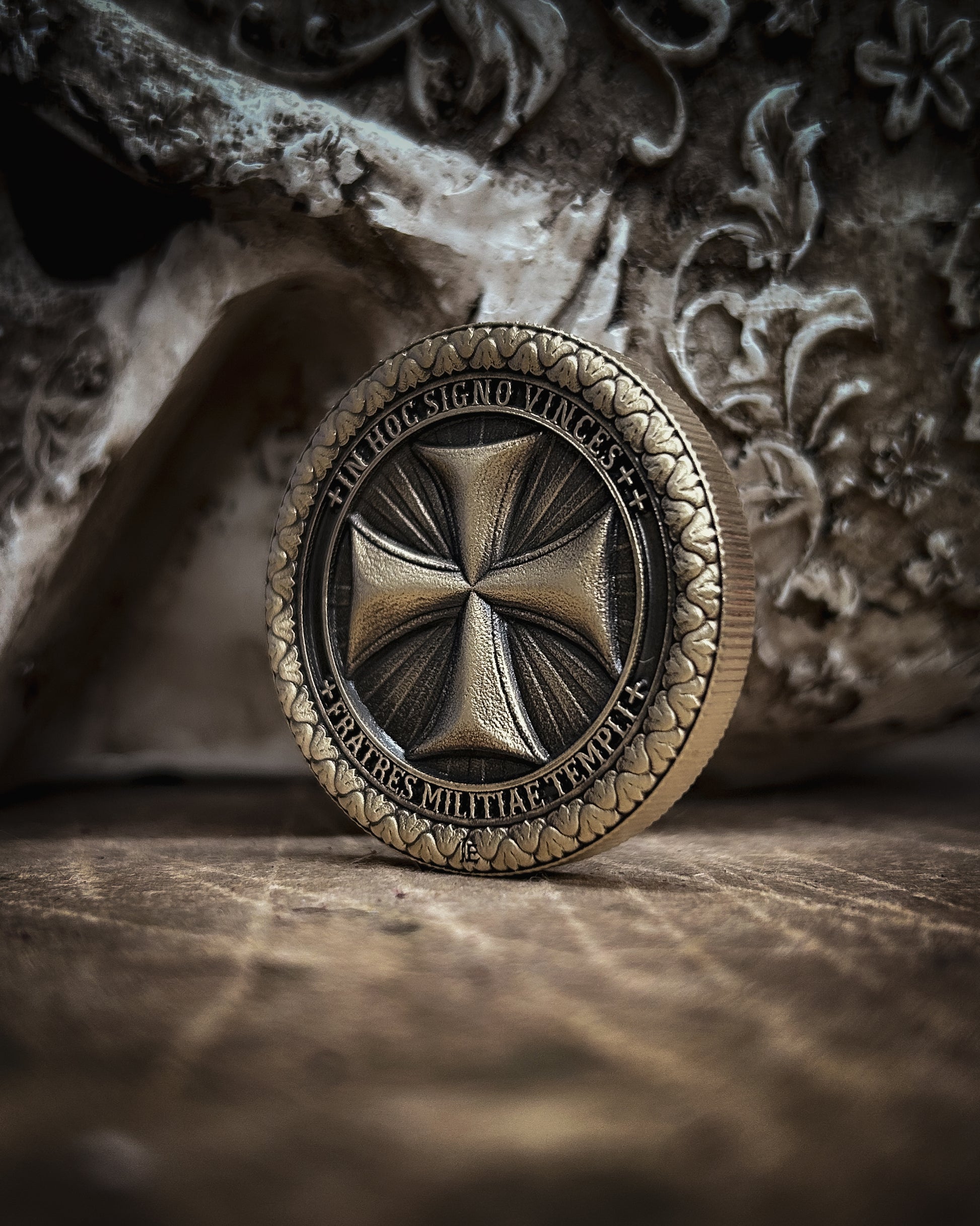 Bronze coin with intricate design on a textured surface