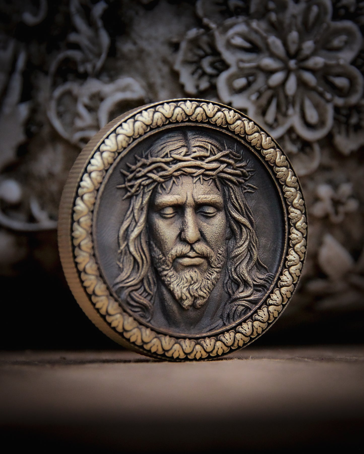Medallion with embossed face of Jesus and crown of thorns on a decorative background