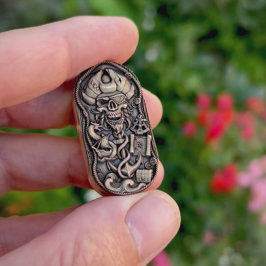 Pirate & Kraken fidget pill featuring a deeply engraved pirate skull and a tentacled sea monster wrapped around an anchor, with an antiqued finish and polished raised details.