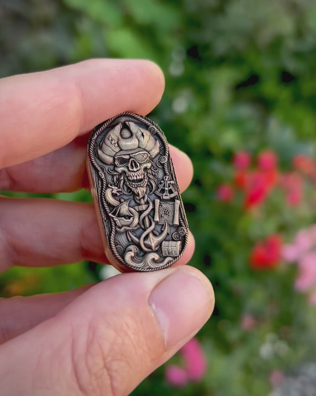 Pirate & Kraken fidget pill featuring a deeply engraved pirate skull and a tentacled sea monster wrapped around an anchor, with an antiqued finish and polished raised details.