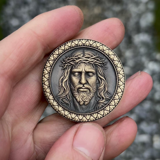 Medallion with embossed face of Jesus Christ wearing a crown of thorns on a textured background.