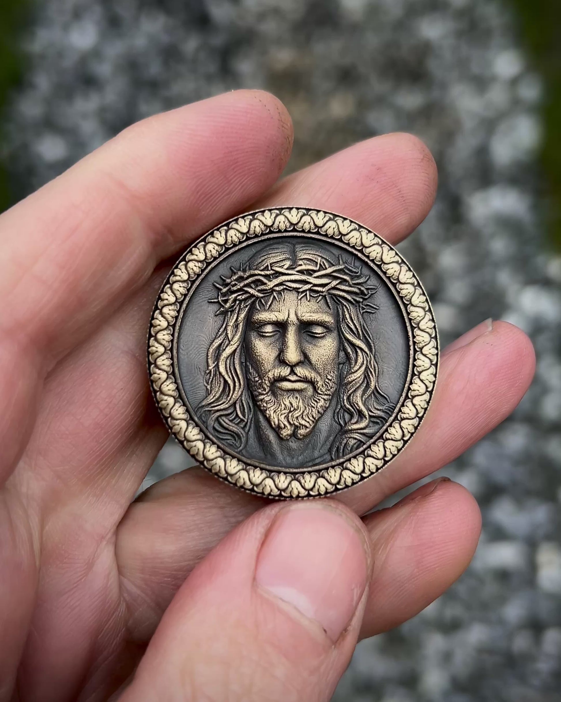 Medallion with embossed face of Jesus Christ wearing a crown of thorns on a textured background.